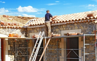 couvreur sur le toit d'un batiment en construction